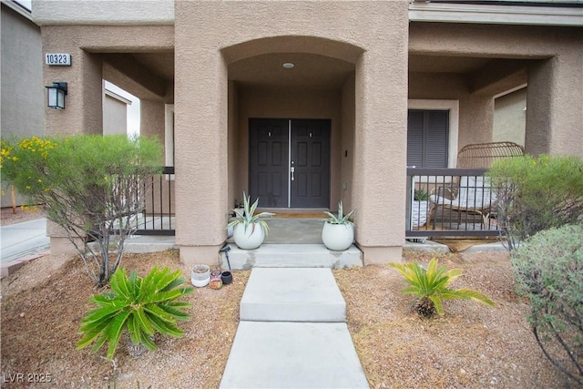 doorway to property featuring stucco siding