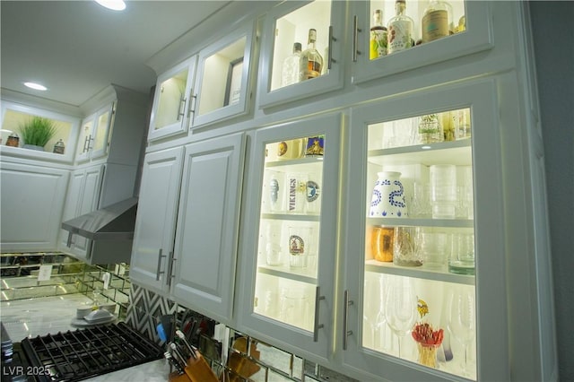 interior details with decorative backsplash, recessed lighting, white cabinetry, and glass insert cabinets