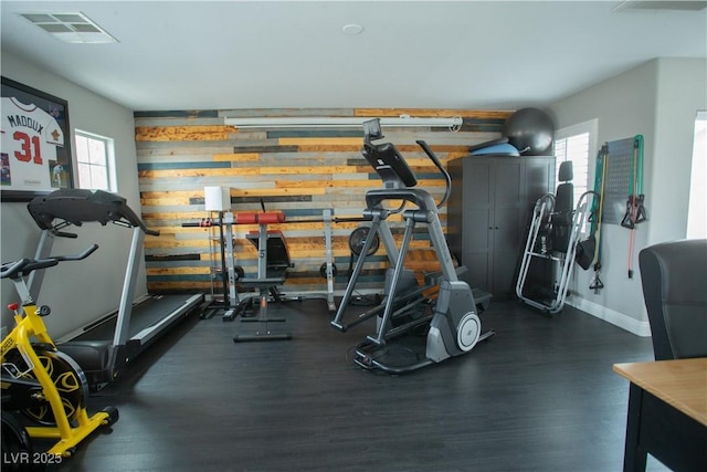 workout area featuring plenty of natural light, wood finished floors, visible vents, and baseboards