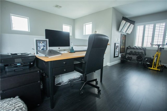 home office featuring dark wood-type flooring, visible vents, and a wealth of natural light