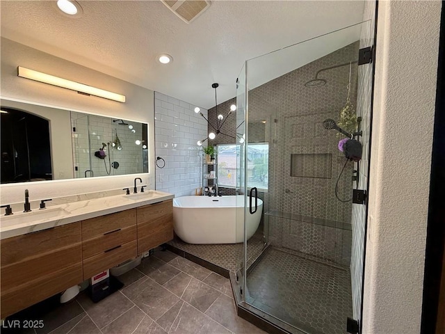 full bath with a sink, a soaking tub, a stall shower, and double vanity