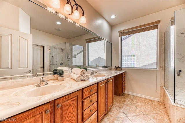 full bathroom featuring double vanity, an enclosed shower, tile patterned floors, and a sink