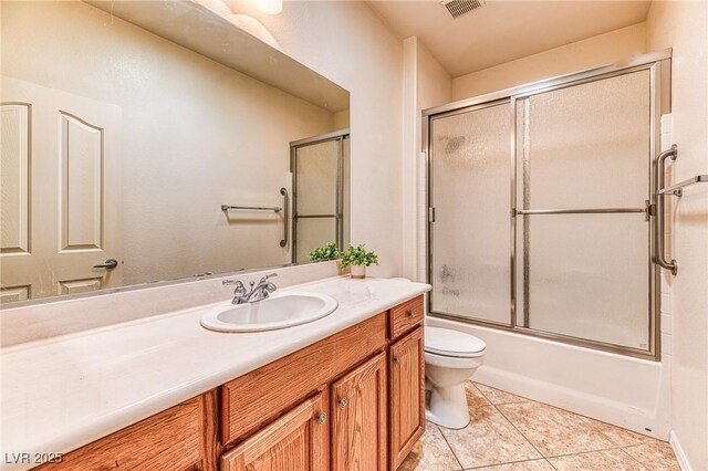 full bathroom featuring tile patterned flooring, visible vents, toilet, combined bath / shower with glass door, and vanity