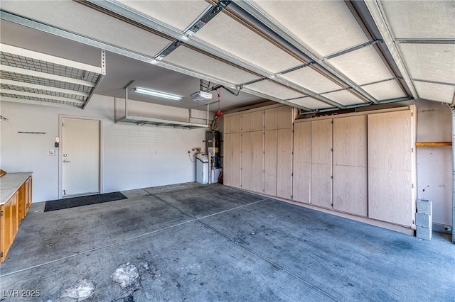 garage featuring water heater and a garage door opener