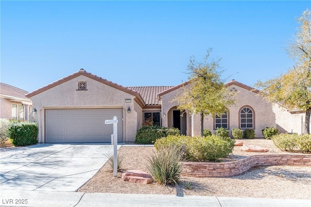 mediterranean / spanish-style home featuring a tile roof, concrete driveway, an attached garage, and stucco siding