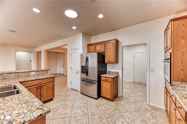 kitchen featuring light stone countertops, recessed lighting, brown cabinets, appliances with stainless steel finishes, and light tile patterned flooring