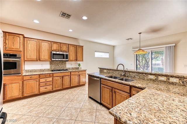 kitchen featuring a sink, brown cabinetry, visible vents, and stainless steel appliances