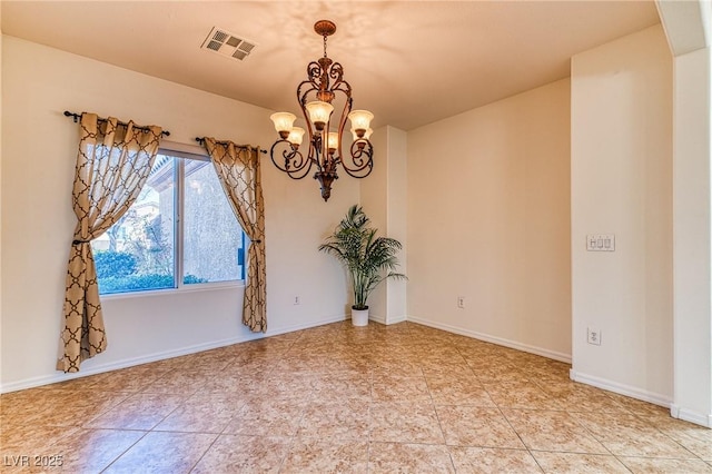 spare room with a chandelier, visible vents, and baseboards