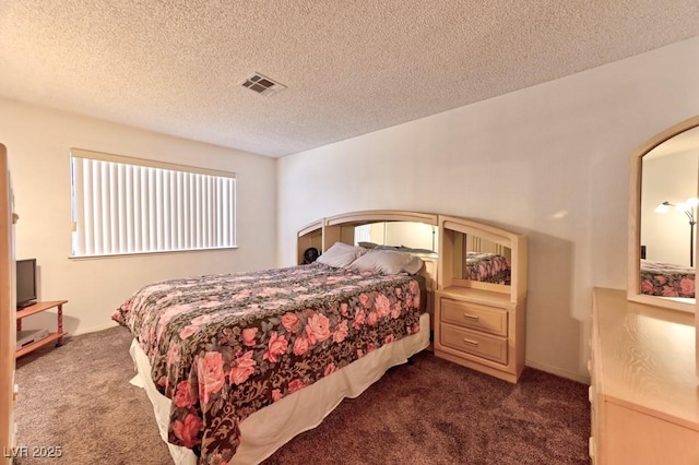 bedroom featuring carpet floors, visible vents, and a textured ceiling