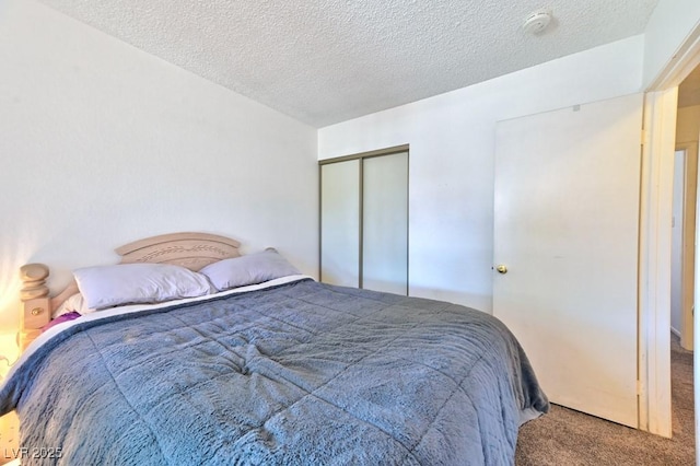 carpeted bedroom with a textured ceiling and a closet