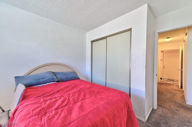 carpeted bedroom featuring a textured ceiling and a closet