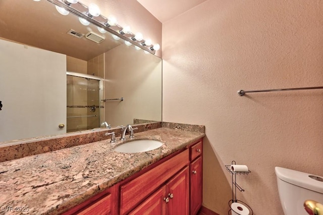 full bathroom with visible vents, vanity, toilet, and an enclosed shower