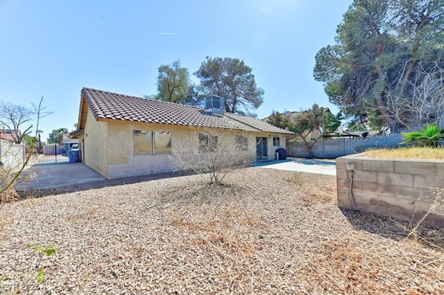 back of house featuring a tiled roof, a patio area, fence, and stucco siding