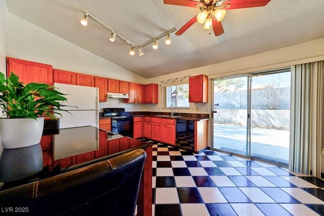 kitchen featuring dark countertops, a sink, vaulted ceiling, under cabinet range hood, and black appliances