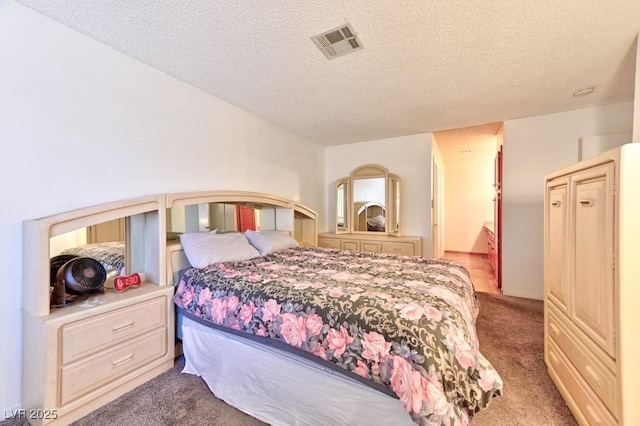 bedroom with a textured ceiling, carpet flooring, and visible vents