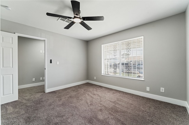 carpeted empty room with a ceiling fan and baseboards