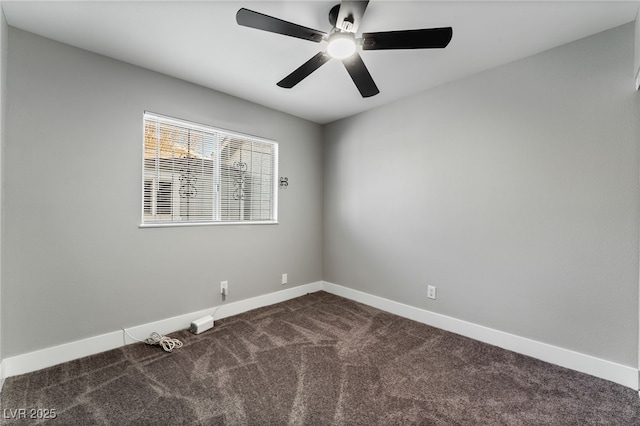 empty room featuring baseboards, dark colored carpet, and a ceiling fan