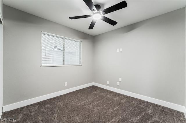 spare room featuring baseboards, dark carpet, and ceiling fan