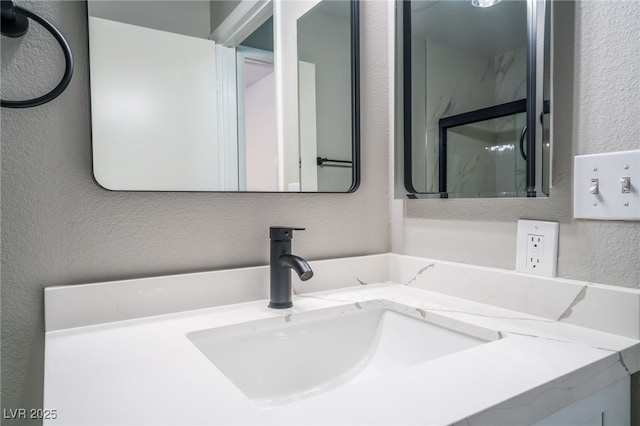 bathroom featuring a textured wall and vanity