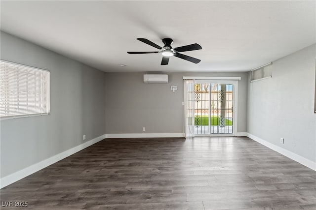 spare room with a wall unit AC, dark wood-style floors, baseboards, and a ceiling fan