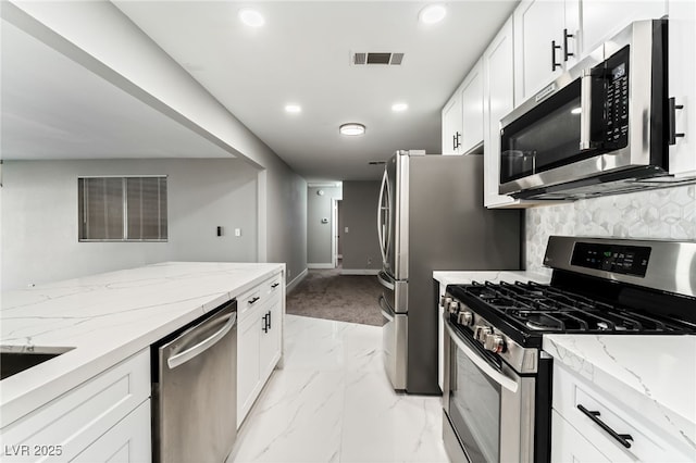 kitchen featuring light stone counters, white cabinetry, visible vents, marble finish floor, and appliances with stainless steel finishes