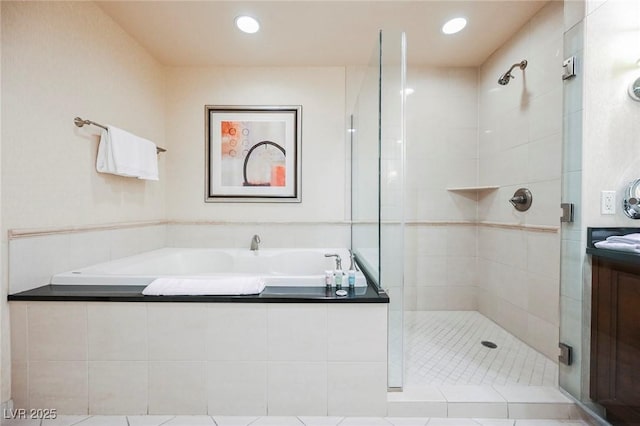 bathroom with a stall shower, a garden tub, and recessed lighting