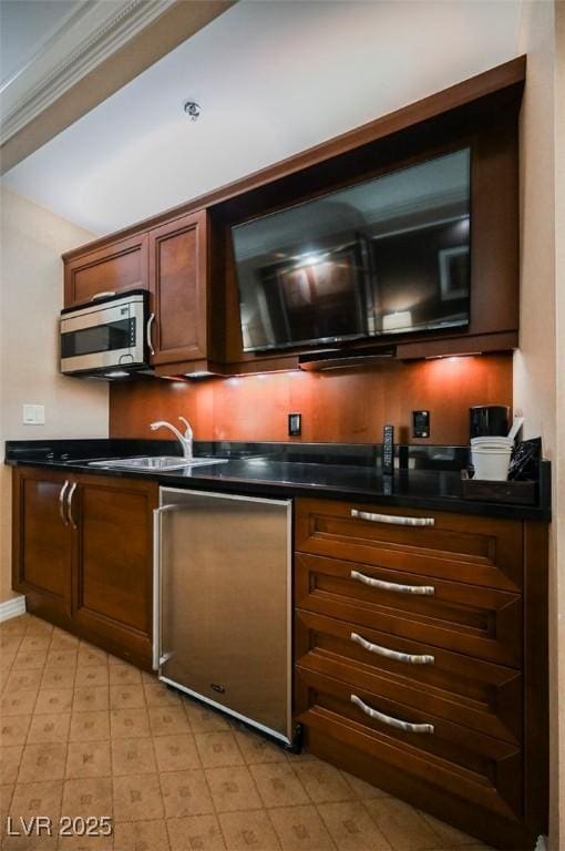 bar featuring dishwashing machine, ornamental molding, stainless steel microwave, and a sink