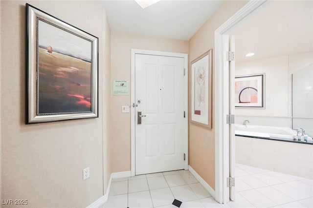 doorway to outside featuring light tile patterned floors and baseboards