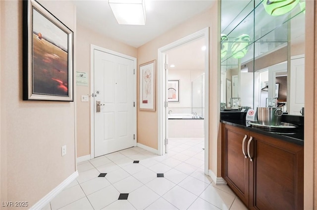 entryway with light tile patterned flooring and baseboards