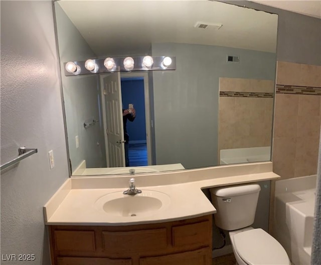 bathroom with a bathtub, visible vents, vanity, and toilet