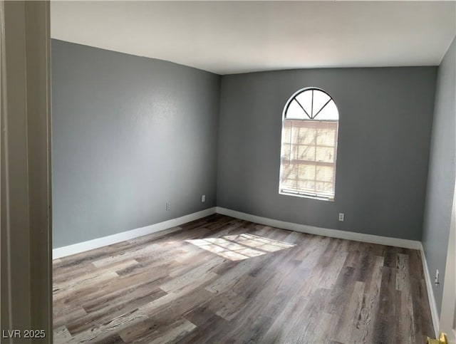 spare room with wood finished floors and baseboards