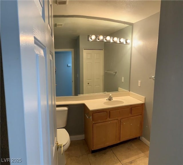 bathroom with vanity, tile patterned flooring, toilet, and baseboards