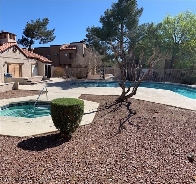 community pool with a patio and fence