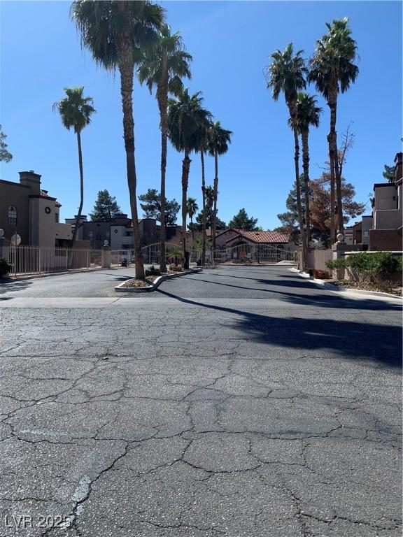 view of road featuring curbs, a gate, and a residential view