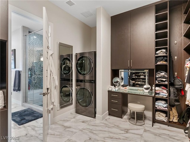 laundry room featuring laundry area, visible vents, stacked washer and clothes dryer, and marble finish floor