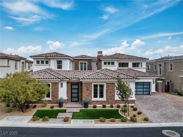 view of front of home featuring stucco siding, a tile roof, decorative driveway, stone siding, and an attached garage