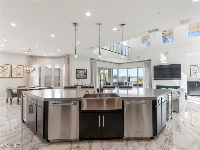 kitchen featuring open floor plan, dishwasher, and a sink