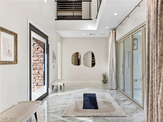 hall featuring visible vents, marble finish floor, recessed lighting, a high ceiling, and baseboards