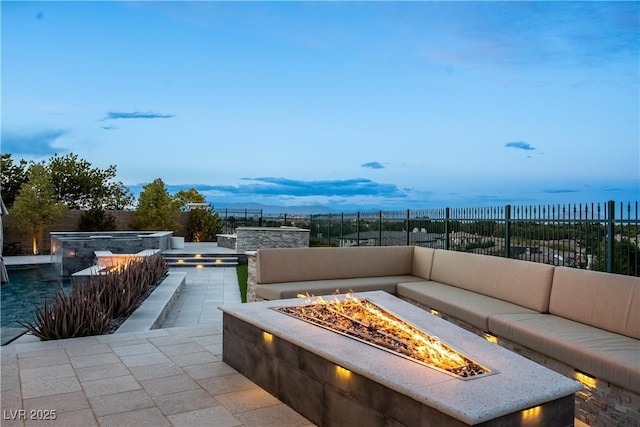 view of patio featuring an outdoor living space with a fire pit, an outdoor hot tub, and fence