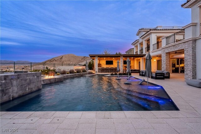 view of pool featuring a ceiling fan, fence, a mountain view, a fenced in pool, and a patio area