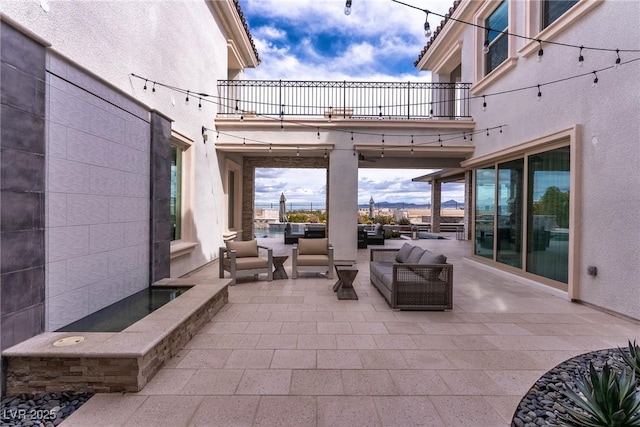 view of patio featuring an outdoor living space and a balcony