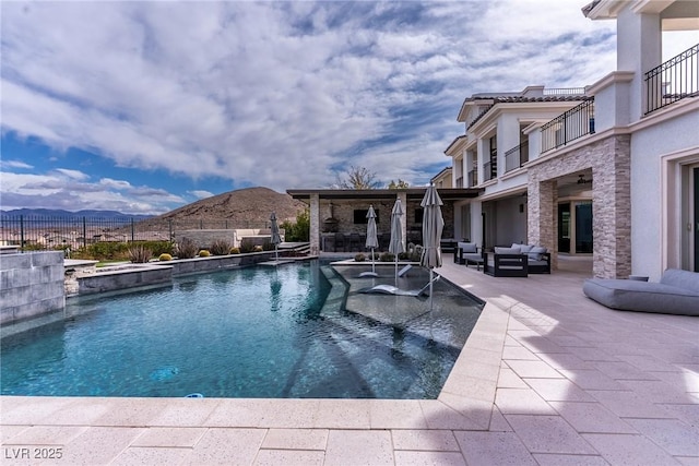 view of pool featuring an outdoor living space, a fenced in pool, fence, a mountain view, and a patio