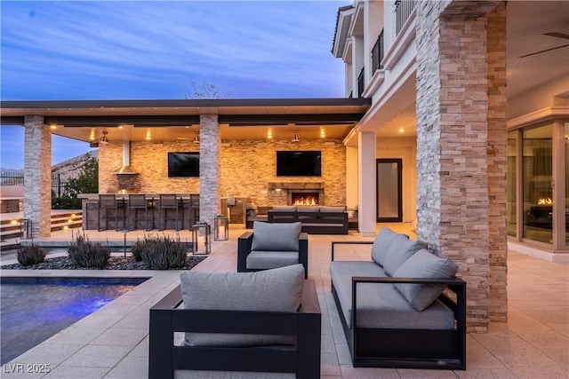 view of patio featuring an outdoor living space with a fireplace and outdoor dry bar