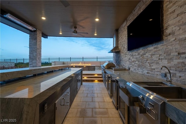 view of patio with exterior kitchen, area for grilling, a fenced backyard, and ceiling fan