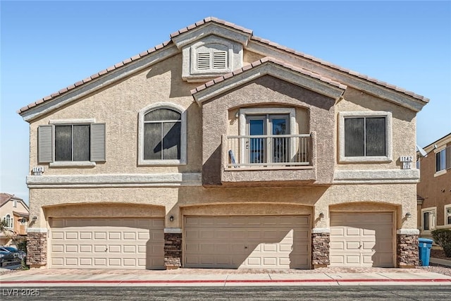 townhome / multi-family property with stone siding, an attached garage, a balcony, and stucco siding