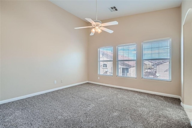 empty room with vaulted ceiling, a wealth of natural light, visible vents, and a ceiling fan