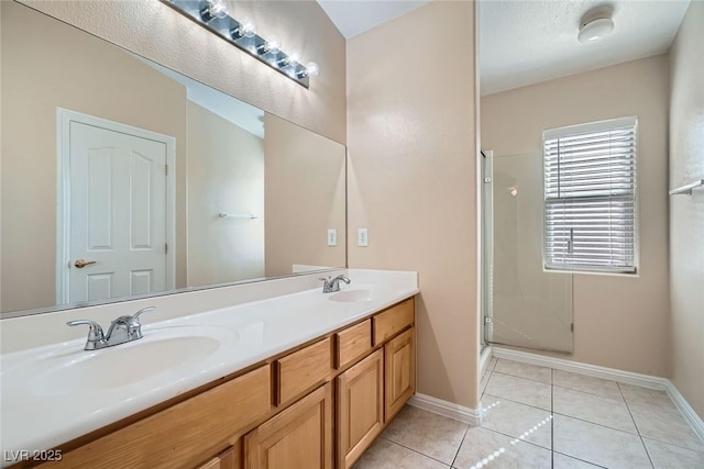 bathroom featuring double vanity, a sink, a shower stall, and tile patterned floors