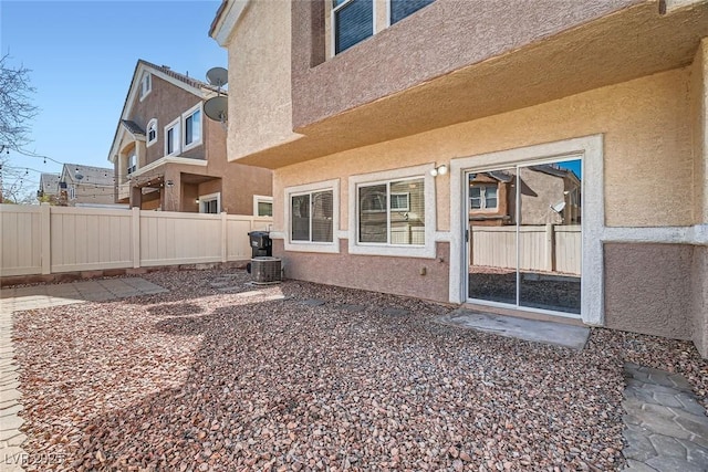 back of property with central AC, a patio, fence, and stucco siding