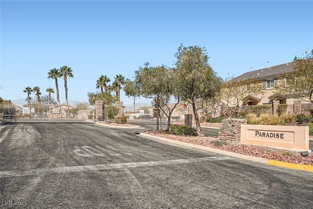 view of road featuring curbs, a gated entry, a residential view, and a gate