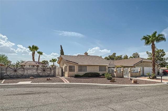 view of front facade with a fenced front yard, a gate, and stucco siding